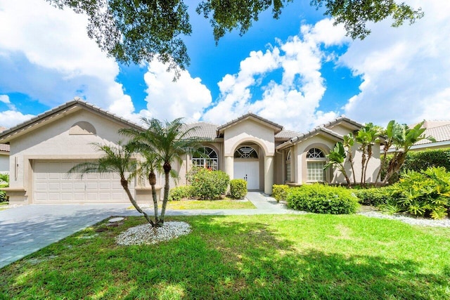 mediterranean / spanish-style house with a garage and a front lawn