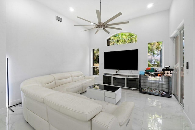 living room featuring ceiling fan and a high ceiling