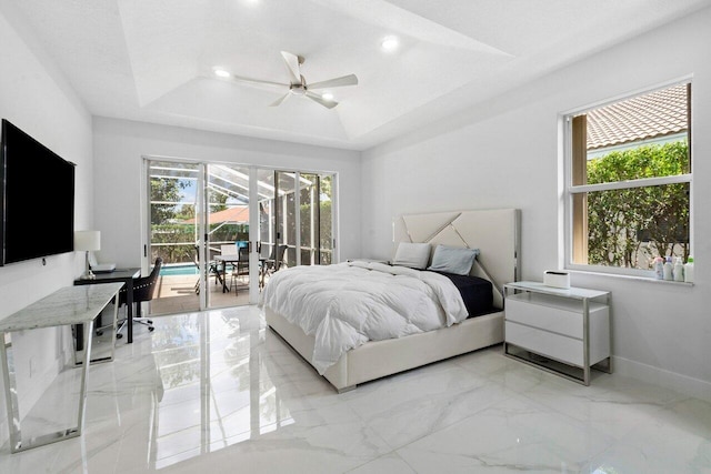 bedroom with access to exterior, a tray ceiling, and ceiling fan