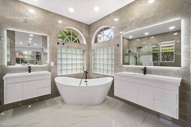 bathroom with plus walk in shower, vanity, and tile walls