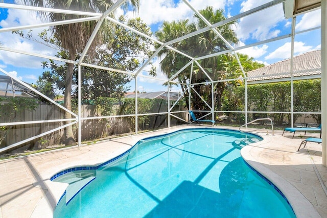 view of swimming pool featuring glass enclosure and a patio