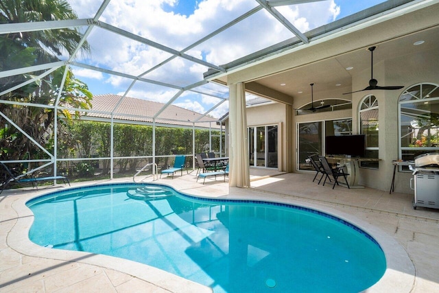 view of swimming pool featuring ceiling fan, a patio area, and glass enclosure