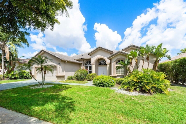 mediterranean / spanish-style home with a front yard and a garage