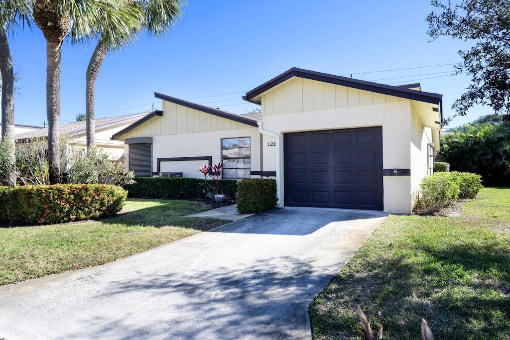 view of front of house featuring a front lawn and a garage