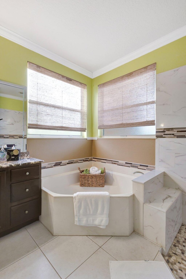 full bath with tile patterned floors, a garden tub, ornamental molding, and vanity