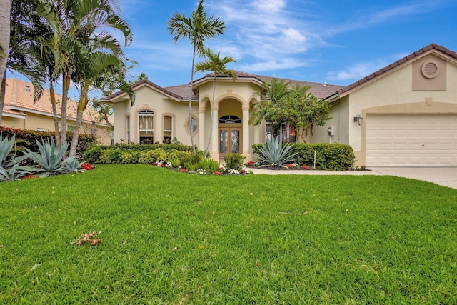 mediterranean / spanish-style house featuring a front lawn, stucco siding, french doors, a garage, and driveway