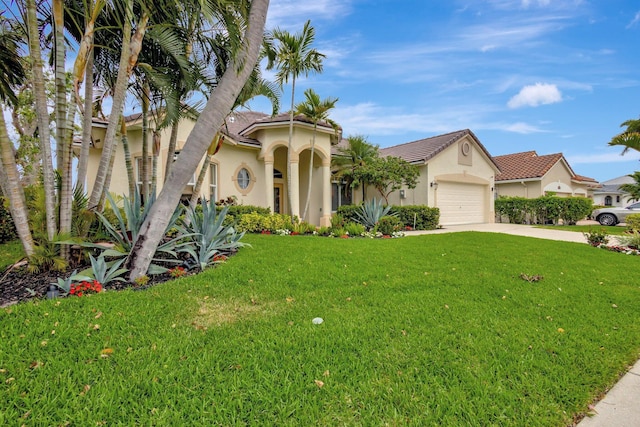 mediterranean / spanish-style home with stucco siding, a front yard, an attached garage, and driveway