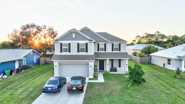 view of front facade featuring a yard, cooling unit, and a garage