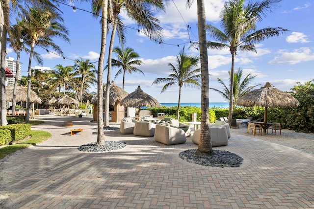 view of home's community with a patio area, an outdoor living space, and a water view