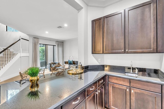 dining space with baseboards, ornamental molding, light wood-type flooring, and an inviting chandelier