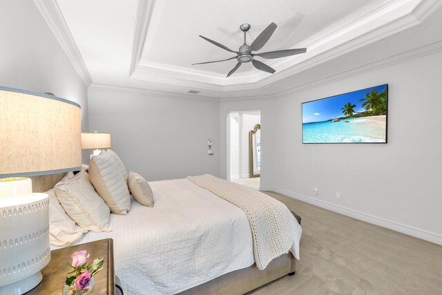 carpeted bedroom featuring ceiling fan, baseboards, ornamental molding, and a raised ceiling