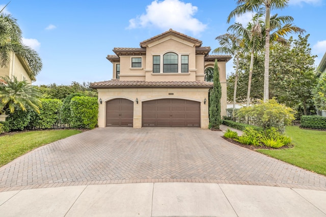 mediterranean / spanish-style home featuring a garage and a front yard