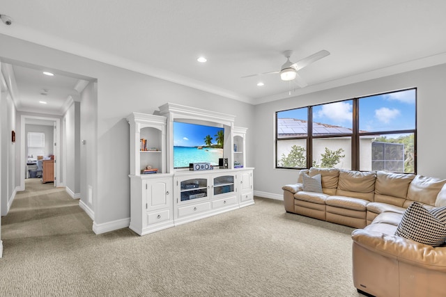 living room with ornamental molding, light colored carpet, and ceiling fan