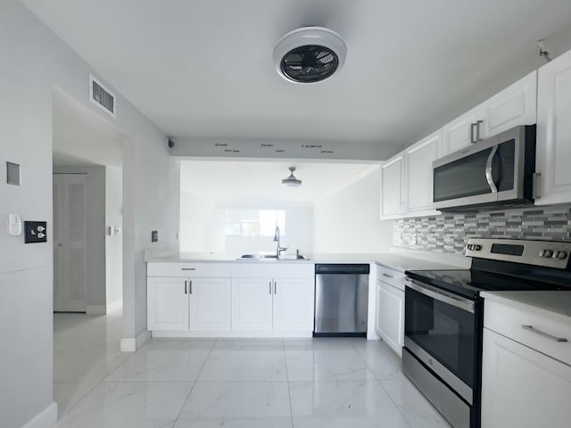 kitchen featuring white cabinets, backsplash, sink, and stainless steel appliances