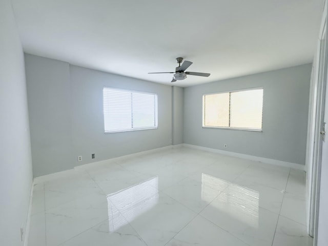 empty room with ceiling fan and a healthy amount of sunlight