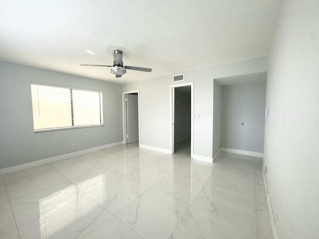 unfurnished bedroom featuring a walk in closet, ceiling fan, and a closet