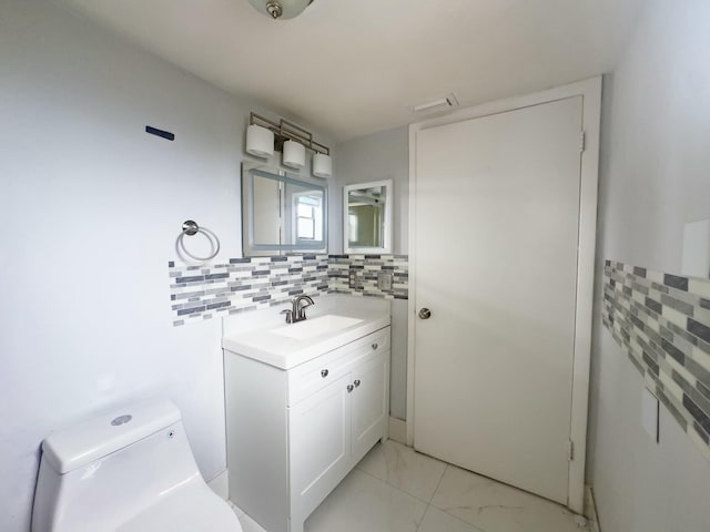 bathroom featuring backsplash, vanity, and toilet