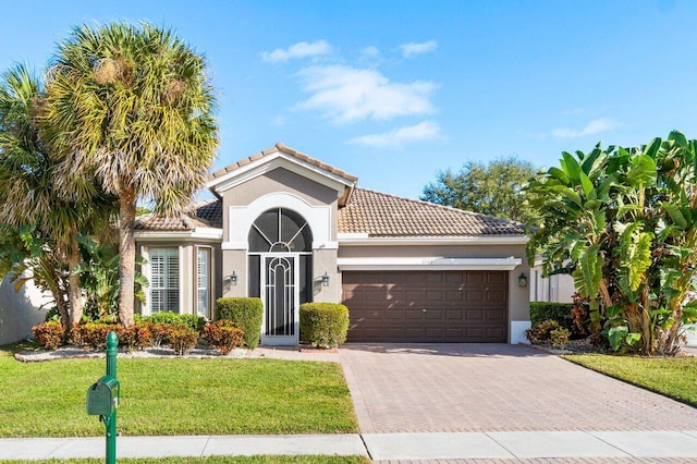 mediterranean / spanish-style house featuring a front yard and a garage