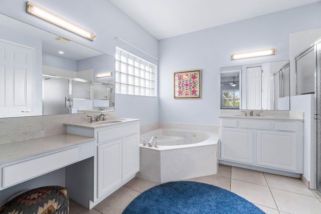 bathroom featuring plus walk in shower, tile patterned floors, a healthy amount of sunlight, and vanity