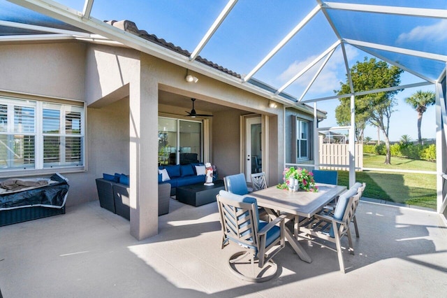 view of patio featuring an outdoor hangout area, ceiling fan, and glass enclosure