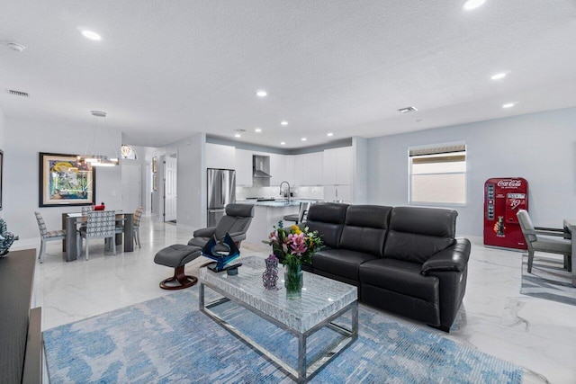 living room with a textured ceiling and sink