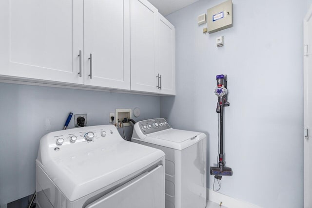 laundry room featuring washing machine and dryer and cabinets