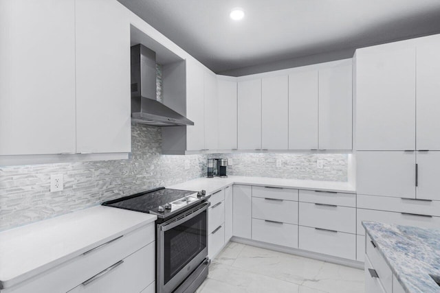 kitchen with white cabinets, stainless steel range with electric cooktop, and wall chimney range hood