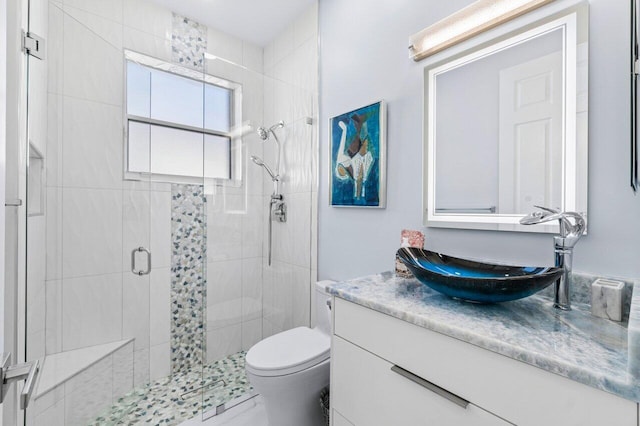 bathroom with an enclosed shower, vanity, and toilet