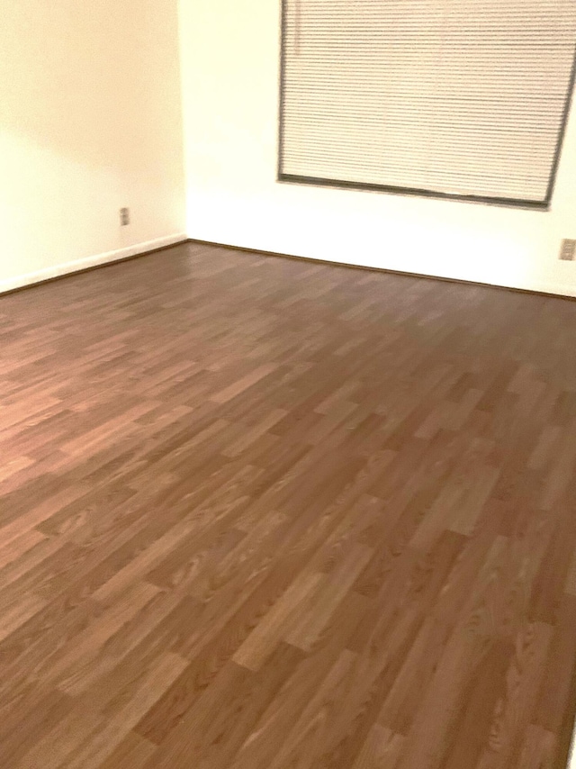 spare room featuring dark wood-type flooring