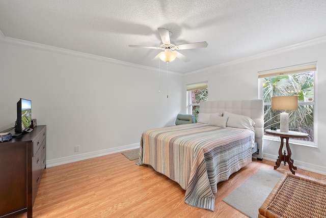 bedroom with a textured ceiling, ceiling fan, light wood-type flooring, and ornamental molding