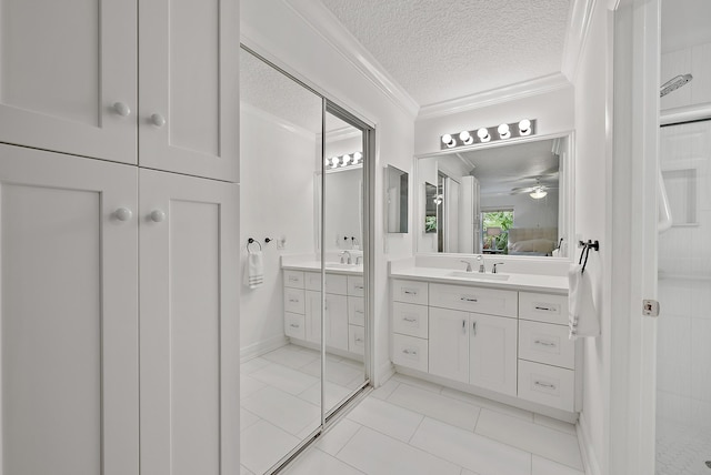 bathroom featuring a textured ceiling, tile patterned flooring, ceiling fan, vanity, and crown molding