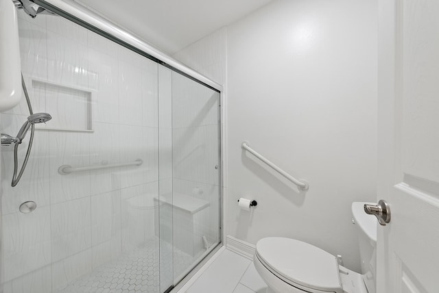 bathroom featuring toilet, an enclosed shower, and tile patterned floors