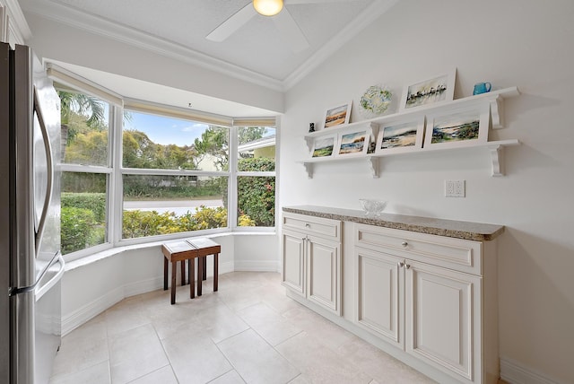 interior space with ceiling fan and a water view