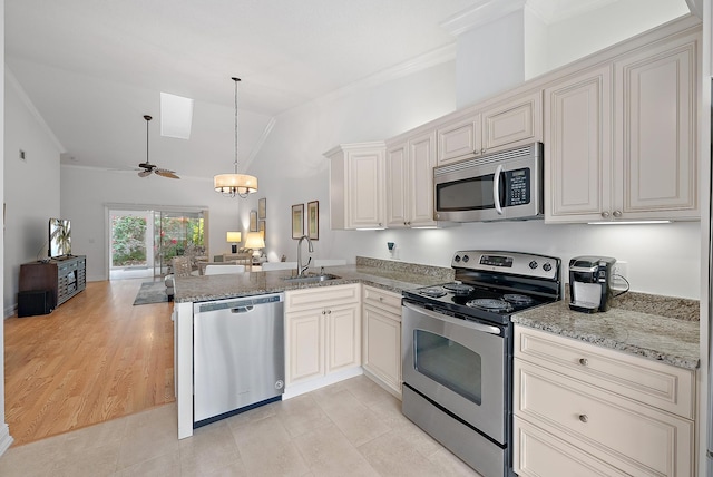 kitchen with ceiling fan with notable chandelier, kitchen peninsula, appliances with stainless steel finishes, and sink