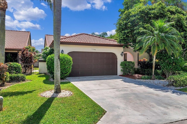 mediterranean / spanish home featuring a front lawn and a garage