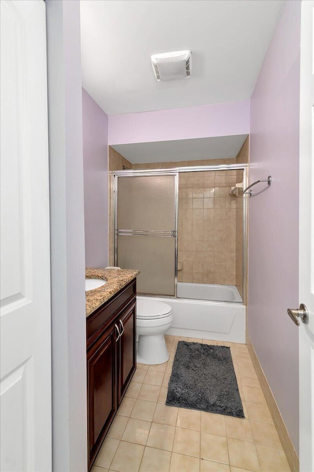 full bathroom featuring tile patterned floors, vanity, toilet, and enclosed tub / shower combo