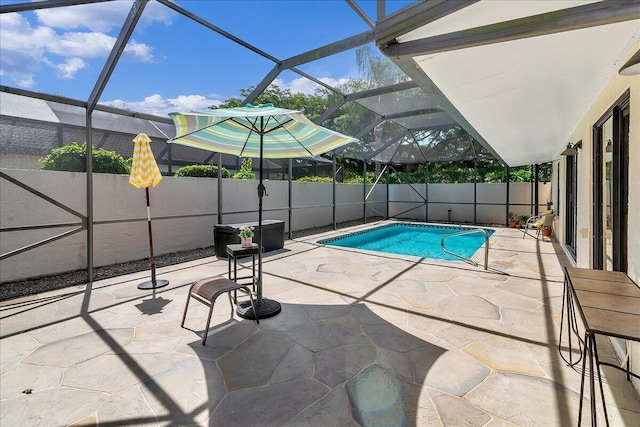 view of swimming pool featuring a patio and glass enclosure