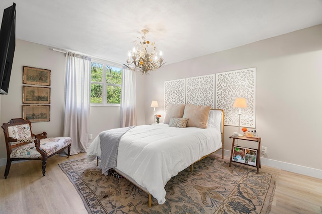 bedroom featuring light wood-type flooring and a notable chandelier