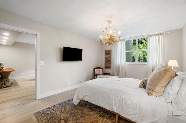 bedroom featuring a notable chandelier and light hardwood / wood-style flooring