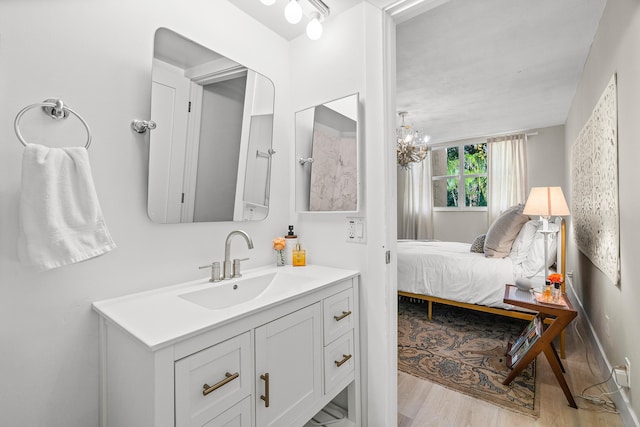 bathroom featuring wood-type flooring, vanity, and a chandelier