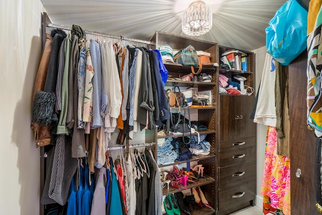 walk in closet featuring a chandelier