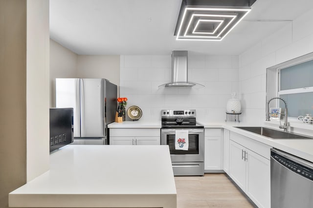 kitchen with white cabinets, stainless steel appliances, wall chimney exhaust hood, sink, and backsplash