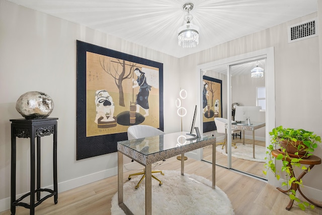 office featuring a notable chandelier and light hardwood / wood-style flooring