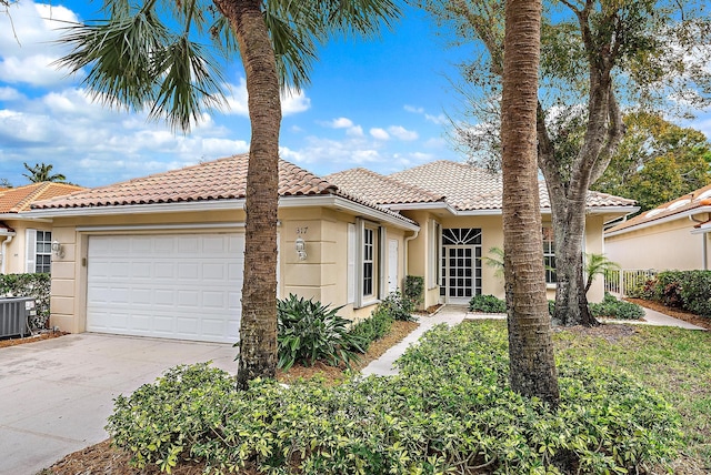 mediterranean / spanish-style house with central AC and a garage