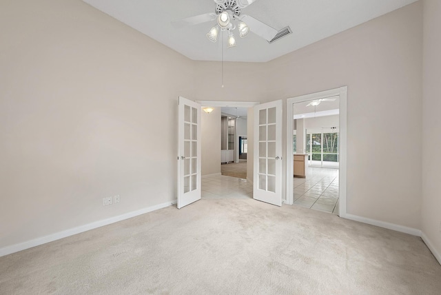 carpeted empty room featuring ceiling fan and french doors