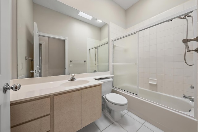 full bathroom with toilet, vanity, tile patterned floors, enclosed tub / shower combo, and a skylight