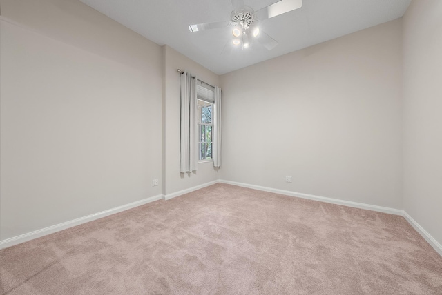 carpeted spare room featuring ceiling fan