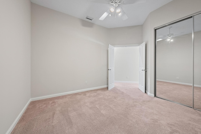 unfurnished bedroom with ceiling fan, a closet, and light colored carpet