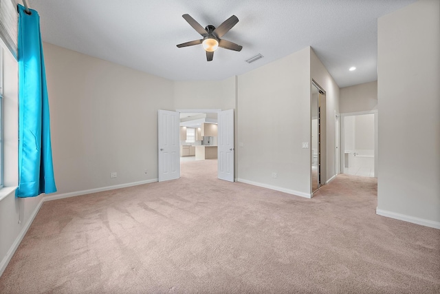 empty room with ceiling fan and light colored carpet