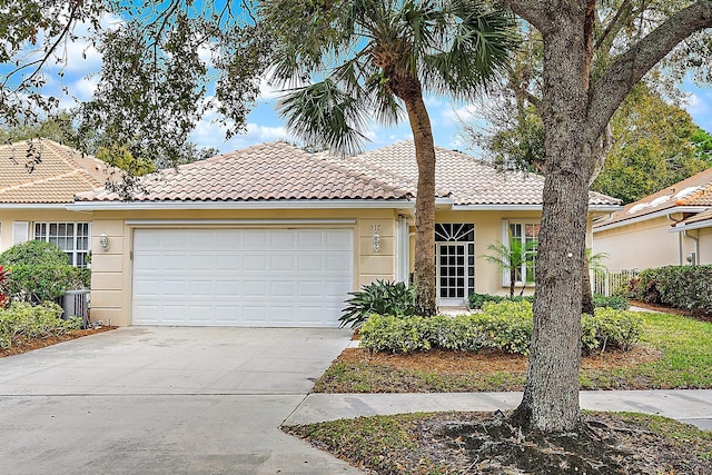 view of front of property featuring a garage and central air condition unit